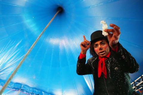 Imagen de un personaje de circo  hacinedo un tuco con un papel